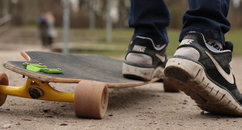 Junge auf Longboard prallt gegen Auto