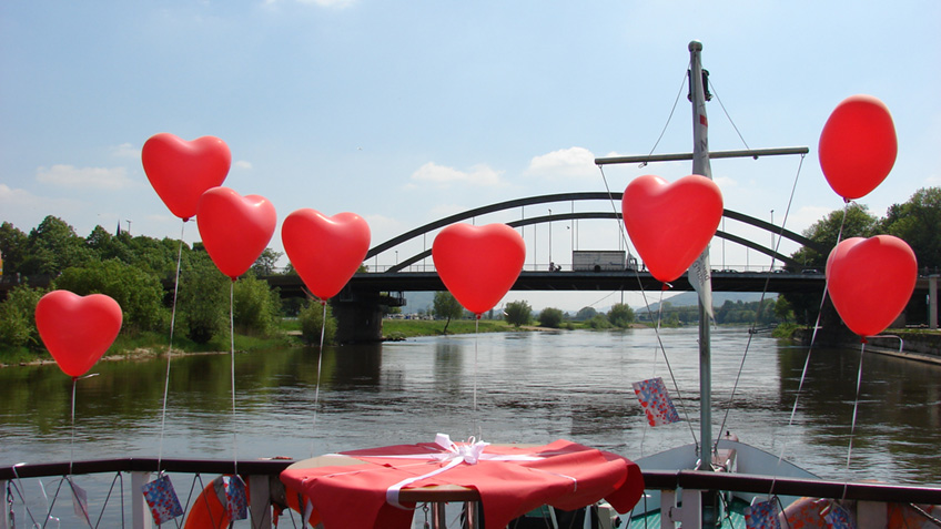  Pr&auml;gend wirkte sich die andauernde Corona-Pandemie auch 2021 auf die Arbeit des Standesamtes der Stadt Minden aus. Zwar waren pers&ouml;nliche Gespr&auml;che im f&uuml;r den freien Publikumsverkehr geschlossenen Rathaus m&ouml;glich, aber immer nur nach Terminvereinbarung. So mussten Besucher*innen an den Eing&auml;ngen des Regierungsgeb&auml;udes abgeholt und auch wieder zur T&uuml;r gebracht werden, was zeitaufw&auml;ndig war. Das Standesamt ist seit der Rathaussanierung und noch bis Ende M&auml;rz 2022 interimsm&auml;&szlig;ig im Regierungsgeb&auml;ude am Weserglacis untergebracht. Ab April wird es eine weitere Interimsl&ouml;sung f&uuml;r das Standesamt geben, da die neuen R&auml;umlichkeiten im Rathaus noch nicht fertiggestellt sind. Wo sich diese R&auml;umlichkeiten befinden werden, stehe derzeit noch nicht abschlie&szlig;end fest.  &bdquo;Es gab viel E-Mail-Verkehr und noch mehr Telefonate. Die Mehraufw&auml;nde haben zu Verz&ouml;gerungen unter anderem in der Bearbeitung von Geburten-Beurkundungen gef&uuml;hrt&ldquo;, fasst der Leiter des Bereiches B&uuml;rgerdienste, Daniel Schollmeyer, r&uuml;ckblickend zusammen. Die Pandemie und die strengen Regeln der NRW-Coronaschutzverordnung stellte das Standesamt insgesamt vor gro&szlig;e Herausforderungen &ndash; auch bei den Trauungen. So war es in 2021 zeitweise nicht erlaubt, Familienmitglieder oder G&auml;ste mit ins Trauzimmer zu nehmen, so Schollmeyer. Mehrere Eheschlie&szlig;ungen fanden nur mit dem Brautpaar und vorhandenen Kindern, viele nur mit dem Brautpaar und den Trauzeugen statt.   Aus dem Grund der reduzierten Personenzahl bei den standesamtlichen Trauungen hatten schon 2020 zahlreiche Heiratswillige ihre Eheschlie&szlig;ung verschoben. Derzeit d&uuml;rfen neben dem Brautpaar und der Standesbeamtin 13 weitere G&auml;ste an der Eheschlie&szlig;ung teilnehmen. Es gilt die 3G-Regel. W&auml;hrend der Eheschlie&szlig;ung ist ein Mund-Nase-Schutz zu tragen. Die st&auml;dtischen Standesbeamtinnen werden seit Beginn der Coronschutzma&szlig;nahmen durch eine transparente Trennwand vor Aerosolen gesch&uuml;tzt. &bdquo;Diese Vorsicht und die Beachtung der Regeln hat unseres Wissen nach zu keiner nachgewiesenen Ansteckung bei einer Eheschlie&szlig;ung in fast zwei Jahren gef&uuml;hrt&ldquo;, berichtet die Koordinatorin des Standesamtes, Bettina Reinking.   Erlaubt war und ist es, drau&szlig;en vor dem Haupteingang das Brautpaar zu bejubeln und zu gratulieren &ndash; aber immer nur mit m&ouml;glichst viel Abstand und empfohlener Maske. Insgesamt wurden nach der jetzt herausgegeben Statistik im vergangenen Jahr 274 Ehen in Minden geschlossen, die meisten (224) davon im Trauzimmer des Regierungsgeb&auml;udes. Im Vorjahr betrug die Zahl der geschlossenen Ehen 298. Anmeldungen zu Eheschlie&szlig;ungen wurden 303 (Vorjahr: 298) verzeichnet, davon 60 (Vorjahr: 52) sogenannte Erm&auml;chtigungen - die Eheschlie&szlig;ung muss beim Wohnsitzstandesamt angemeldet werden, diese findet aber nicht im Standesamt Minden statt. Im Gegenzug haben 44 Paare mit Wohnsitz au&szlig;erhalb Mindens die Ehe im Standesamt Minden geschlossen, oft aufgrund famili&auml;rer Bindungen zur Stadt Minden.  Neben dem Trauzimmer wurden Ehen in Minden &ndash; darunter zwei gleichgeschlechtliche &ndash; auch im LWL-Preu&szlig;enmuseum (1 Paar), auf einem Fahrgastschiff (3), im Heimathaus Dankersen (10) und &ndash; 2021 besonders beliebt &ndash; in der M&uuml;hle Mei&szlig;en (33 &ndash; im Vorjahr 15) - geschlossen. Ein Paar heiratete in einem Waggon der Museumseisenbahn. Es gab auch zwei seltene Nottrauungen im Johannes Wesling Klinikum.   Immer noch die gro&szlig;e Mehrzahl der Paare w&auml;hlt den Nachnamen des Mannes oder 1. Ehegatten zum Ehenamen (205), 19 den Nachnamen der Frau oder des 2. Ehegatten. 50 Paare entschieden sich 2021 dazu, keinen Ehenamen zu bestimmen, bei 19 Paaren w&auml;hlte ein Ehegatte einen &bdquo;Doppelnamen&ldquo;, das hei&szlig;t sie/er stellte dem Ehenamen einen Namen voran oder f&uuml;gte dem Ehenamen einen Namen hinzu.  &bdquo;Die Pandemie hatte durchaus Einfluss auf die Zahl der Eheschlie&szlig;ungen, denn es gab 2020 und 2021 rund 100 weniger als im coronafreien Jahr 2019. Da waren es insgesamt 394&ldquo;, so Bettina Reinking. &bdquo;Ich bin mir sicher, dass die Anzahl der Eheschlie&szlig;ungen wieder steigt, wenn es keine coronabedingten Einschr&auml;nkungen mehr geben wird&ldquo;. Eine Eheschlie&szlig;ung stelle auch heute noch f&uuml;r das Brautpaar einen besonderen Moment im Leben dar, den man gerne mit engen Familienmitgliedern und nahen Freunden teilen m&ouml;chte, ohne Abstriche auf der G&auml;steliste. Da werde der Termin oft sogar mehrmals verschoben, was die Anzahl der geschlossenen Ehen dann merklich reduziere, so Reinking weiter.  Einfluss auf die Zahl der Geburten hatte Corona 2021 nicht &ndash; eher im Gegenteil. Denn es wurden mehr Babys in Minden geboren als im Jahr 2020. 984 M&auml;dchen und 1.076 Jungen &ndash; also insgesamt 2.060  Kinder - erblickten bis zum 31. Dezember nach der Statistik das Licht der Welt. 2020 waren es 1.950, in den Vorjahren &auml;hnlich viele. Sieben der 2.060 beurkundeten Kinder sind im Ausland geboren. Erg&auml;nzend weist die Koordinatorin des Standesamtes darauf hin, dass Babys, die knapp vor dem Jahresende geboren und deren Geburt bis zum Jahresende nicht angezeigt ist, im Folgejahr beurkundet werden und dann Ber&uuml;cksichtigung in der Statistik des n&auml;chsten Jahres finden.  Die traurigste Zahl des Jahres sind immer die Sterbef&auml;lle: Deren Anzahl ist nach 2020 - hier waren es 1.740 und 2019 1.667 - weiter auf 1.781 beurkundete F&auml;lle gestiegen. Darunter befinden sich auch mehrere Personen, die an oder in Verbindung mit Covid-19 verstorben sind.  Das Standesamt beurkundet neben dem Jugendamt auch Vaterschaftsanerkennungen (2021: 138) sowie zahlreiche namensrechtliche Erkl&auml;rungen (Wiederannahme des Geburtsnamens nach Aufl&ouml;sung der Ehe, Hinzuf&uuml;gung des Namens zum Ehenamen, Wiederruf der Hinzuf&uuml;gung zum Ehenamen, Namenserteilungen f&uuml;r Kinder, Angleichungserkl&auml;rungen, Sortierung der Vornamen etc.), deren Anzahl stetig steigt.  &bdquo;Corona hat uns auch in 2021 wieder vor gro&szlig;e Herausforderungen in der Erledigung der t&auml;glichen Arbeit gestellt&ldquo;, so Reinking. Die Abarbeitung der Einzelf&auml;lle war arbeitsintensiver und nahm einen gr&ouml;&szlig;eren Zeitrahmen in Anspruch. Auch Gespr&auml;che mit ausl&auml;ndischen Mitb&uuml;rger*innen gestalteten sich ohne pers&ouml;nlichen Kontakt und mit Verst&auml;ndigungsschwierigkeiten meist schwierig. Es wurden daher in einigen F&auml;llen Dolmetscher*innen einbezogen und Sachverhalte mussten oft mehrfach er&ouml;rtert werden.