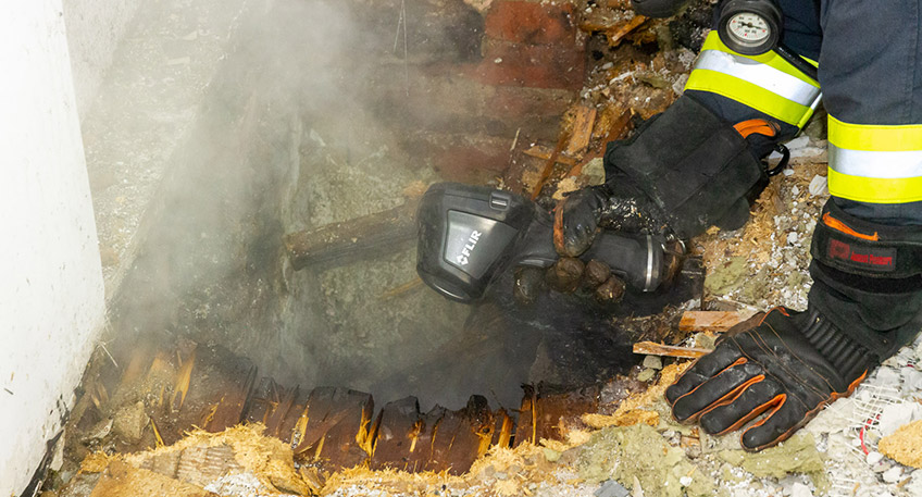 Die Freiwillige Feuerwehr Porta Westfalica wurde am Mittwoch, 16.11.2022, gegen 00:21 Uhr zu einem Wohnhausbrand im Ortsteil Holtrup, Holtruper Stra&szlig;e alarmiert. Durch die Feuerwehr wurde eine Person aus dem Haus geborgen, diese hatte schwere Brandverletzungen erlitten und verstarb noch an der Einsatzstelle. 4 weitere Personen, darunter 1 Kind, konnten das Haus aus eigener Kraft verlassen.  Bei Eintreffen der Feuerwehr hatten 4 Personen, darunter 1 Kind, das Haus bereits aus eigener Kraft verlassen. Von diesen 4 Personen hatten 2 Rauchgase eingeatmet, sie hatten noch versucht einem Bewohner im Erdgescho&szlig; zu Hilfe zu kommen. Ein Angriffstrupp der Hauptamtlichen Feuer- und Rettungswache ging unter schwerem Atemschutz in das Geb&auml;ude zur Menschenrettung vor. Die vermisste Person wurde im Erdgescho&szlig; mit schwersten Brandverletzungen aufgefunden und durch den Trupp ins Freie gebracht. Rettungsdienst und Notarzt &uuml;bernahmen den Patienten, konnten aber leider nur noch den Tod feststellen.  Die 4 Personen aus dem Haus wurden rettungsdienstlich versorgt und durch Notfallseelsorger vor Ort betreut. Die Feuerwehr ging mit insgesamt 4 Trupps unter schwerem Atemschutz und 2 C-Rohren gegen den Brand vor. Das Feuer hatte ein Zimmer komplett zerst&ouml;rt, Brandrauch hatte sich im Haus ausgebreitet. Das Haus wurde mit Hochdruckl&uuml;ftern entraucht, im Brandraum wurden Glutnester abgel&ouml;scht und Mobiliar nach au&szlig;erhalb verbracht. Mit einer W&auml;rmebildkamera wurde die Einsatzstelle &uuml;berpr&uuml;ft.  Gegen 01:30 Uhr konnten erste Kr&auml;fte abr&uuml;cken, gegen 01:50 Uhr wurde die Einsatzstelle der Polizei &uuml;bergeben und der Einsatz beendet.