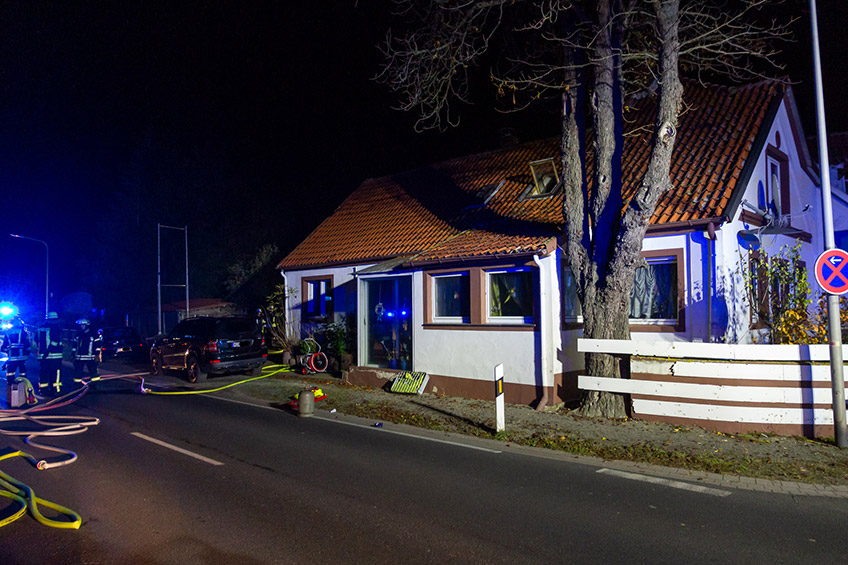 Die Freiwillige Feuerwehr Porta Westfalica wurde am Mittwoch, 16.11.2022, gegen 00:21 Uhr zu einem Wohnhausbrand im Ortsteil Holtrup, Holtruper Stra&szlig;e alarmiert. Durch die Feuerwehr wurde eine Person aus dem Haus geborgen, diese hatte schwere Brandverletzungen erlitten und verstarb noch an der Einsatzstelle. 4 weitere Personen, darunter 1 Kind, konnten das Haus aus eigener Kraft verlassen.  Bei Eintreffen der Feuerwehr hatten 4 Personen, darunter 1 Kind, das Haus bereits aus eigener Kraft verlassen. Von diesen 4 Personen hatten 2 Rauchgase eingeatmet, sie hatten noch versucht einem Bewohner im Erdgescho&szlig; zu Hilfe zu kommen. Ein Angriffstrupp der Hauptamtlichen Feuer- und Rettungswache ging unter schwerem Atemschutz in das Geb&auml;ude zur Menschenrettung vor. Die vermisste Person wurde im Erdgescho&szlig; mit schwersten Brandverletzungen aufgefunden und durch den Trupp ins Freie gebracht. Rettungsdienst und Notarzt &uuml;bernahmen den Patienten, konnten aber leider nur noch den Tod feststellen.  Die 4 Personen aus dem Haus wurden rettungsdienstlich versorgt und durch Notfallseelsorger vor Ort betreut. Die Feuerwehr ging mit insgesamt 4 Trupps unter schwerem Atemschutz und 2 C-Rohren gegen den Brand vor. Das Feuer hatte ein Zimmer komplett zerst&ouml;rt, Brandrauch hatte sich im Haus ausgebreitet. Das Haus wurde mit Hochdruckl&uuml;ftern entraucht, im Brandraum wurden Glutnester abgel&ouml;scht und Mobiliar nach au&szlig;erhalb verbracht. Mit einer W&auml;rmebildkamera wurde die Einsatzstelle &uuml;berpr&uuml;ft.  Gegen 01:30 Uhr konnten erste Kr&auml;fte abr&uuml;cken, gegen 01:50 Uhr wurde die Einsatzstelle der Polizei &uuml;bergeben und der Einsatz beendet.